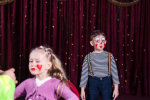 boy-dressed-as-clown-wearing-make-up-striped-shirt-standing-stage-with-red-curtain-girl-having-make-up-applied-face-foreground_385506-4300.jpg